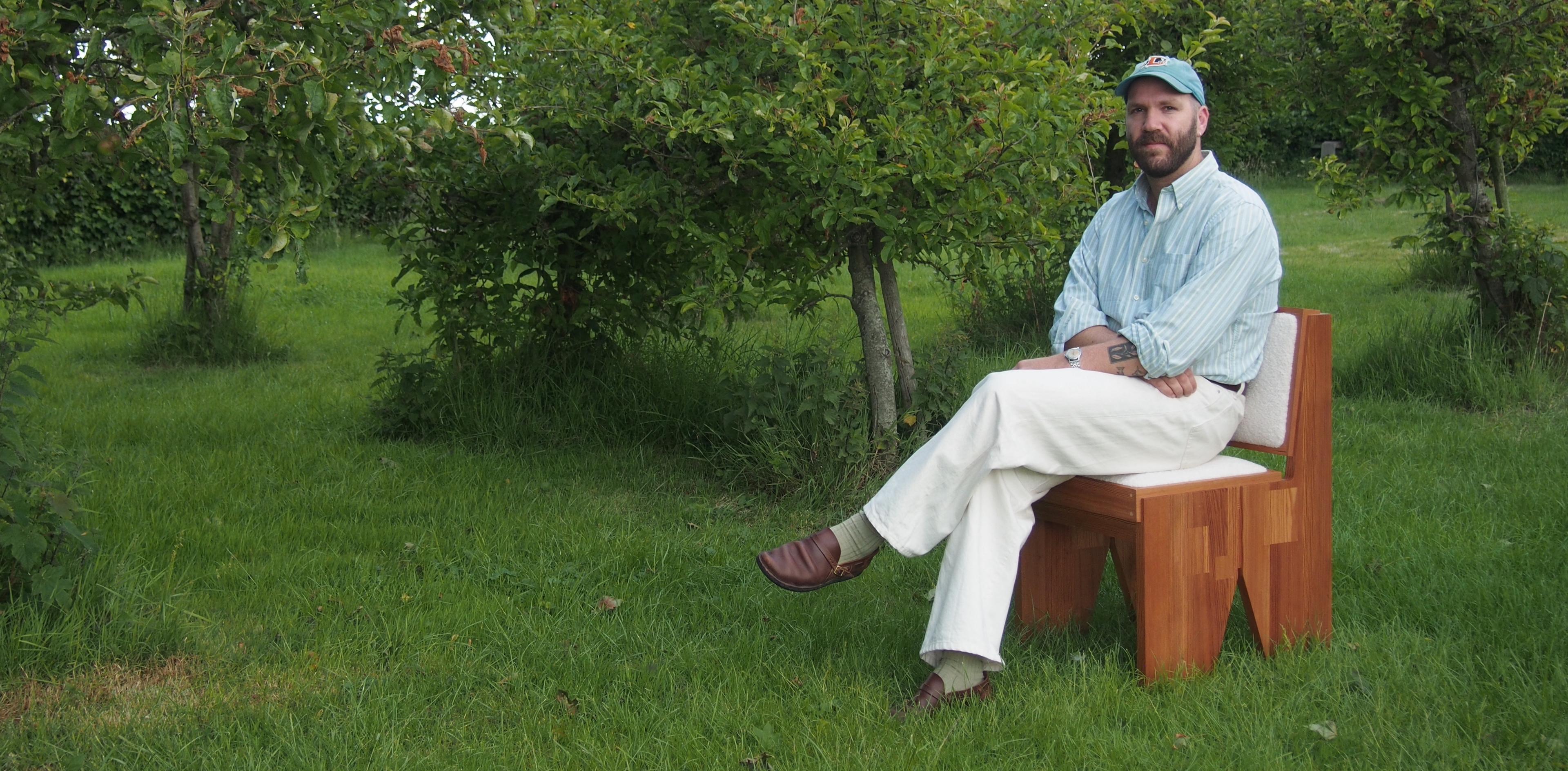 Kristian, founder of Studio Phazant, sitting on his handmade chair