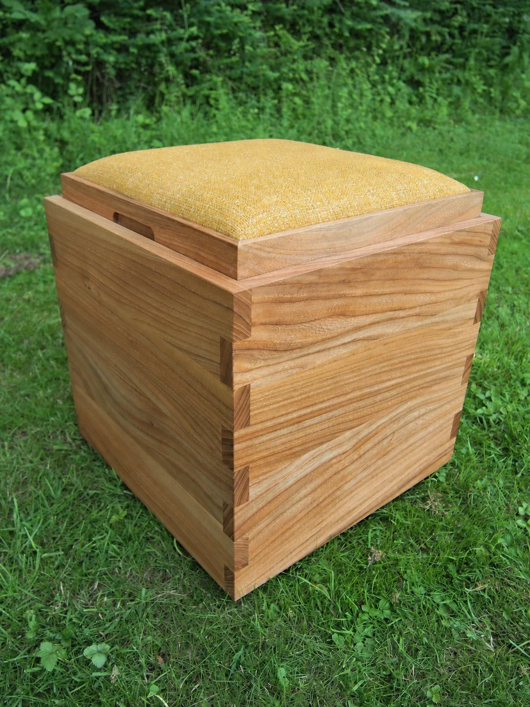 KUBE stool with its yellow upholstered seat, viewed from the side