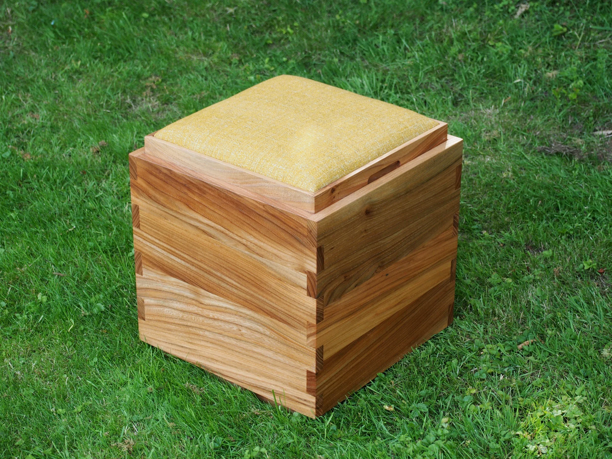 KUBE stool with its yellow upholstered seat on the lawn